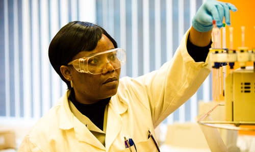 Researcher picking up test tube from machine